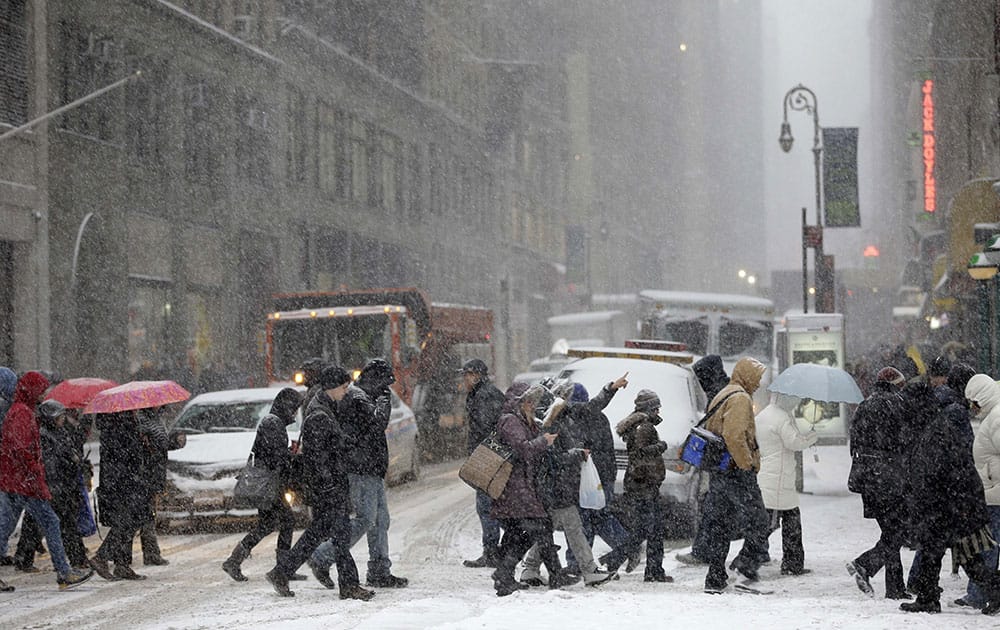 Pedestrians walk through heavy snow in the midtown section of New York. More than 35 million people along the Philadelphia-to-Boston corridor rushed to get home and settle in Monday as a fearsome storm swirled in with the potential of 1 to 3 feet of snow that could paralyze the Northeast for days. 