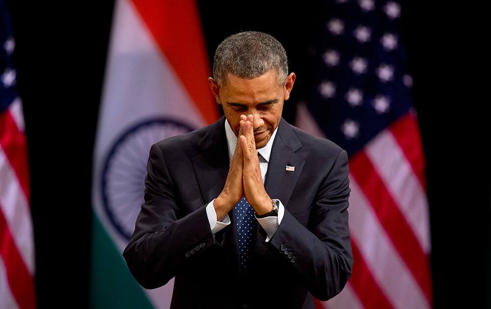 U.S. President Barack Obama folds his hands together in a traditional Indian greeting gesture at the Siri Fort Auditorium, in New Delhi.