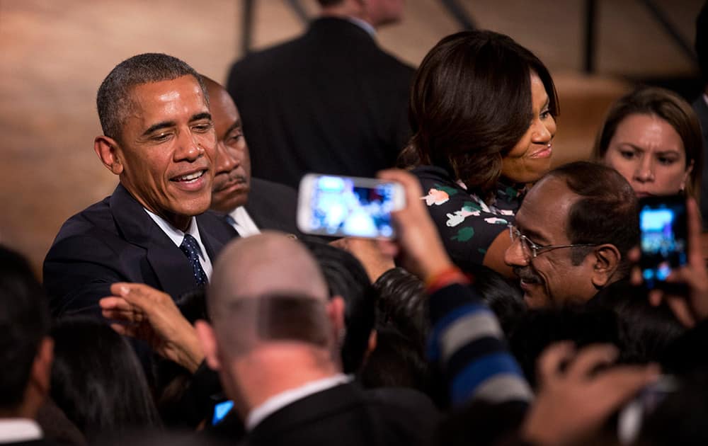 U.S. President Barack Obama and first lady Michelle Obama interact with the crowd at the Siri Fort Auditorium, in New Delhi.