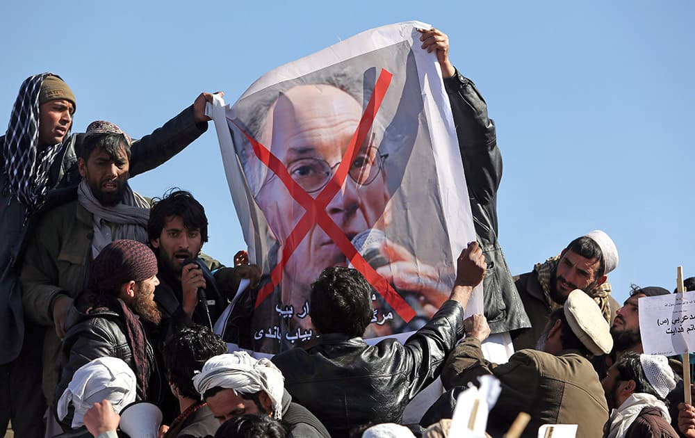 Afghans hold poster of French magazine Charlie Hebdo editor in chief, Gerard Briard, during a protest against caricatures published in the magazine in Kabul, Afghanistan.