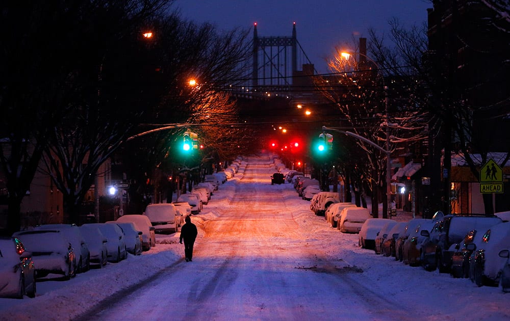 A pedestrian walks along 24th Avenue in the Astoria neighborhood of the Queens borough of New York.