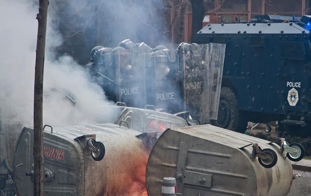 Police in riot gear are pelted with stones in Kosovo capital Pristina during a protest.