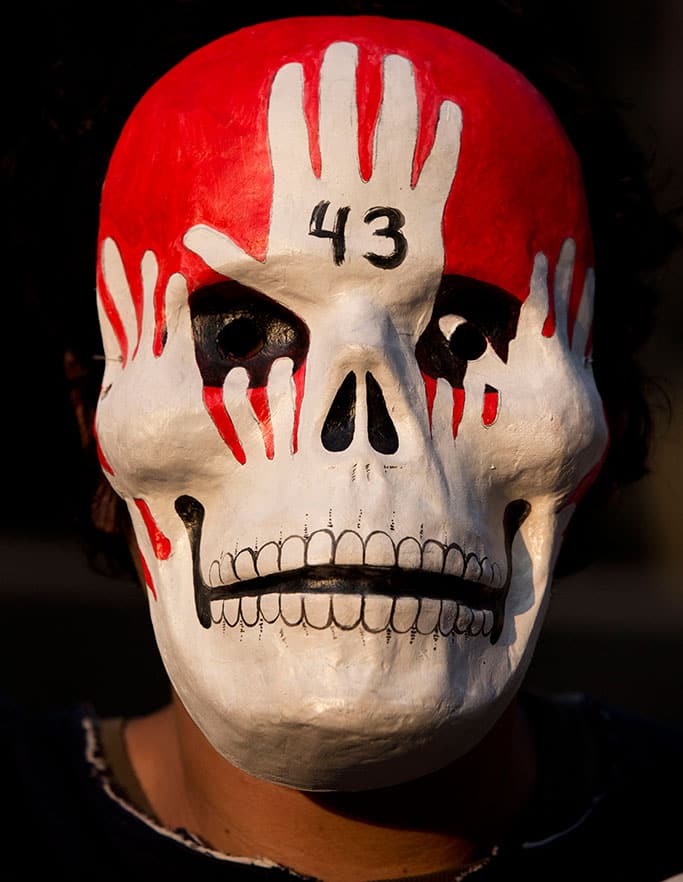 A protestor wears a mask during a march marking four months since the disappearance of 43 students from a rural teachers' college, in Mexico City.