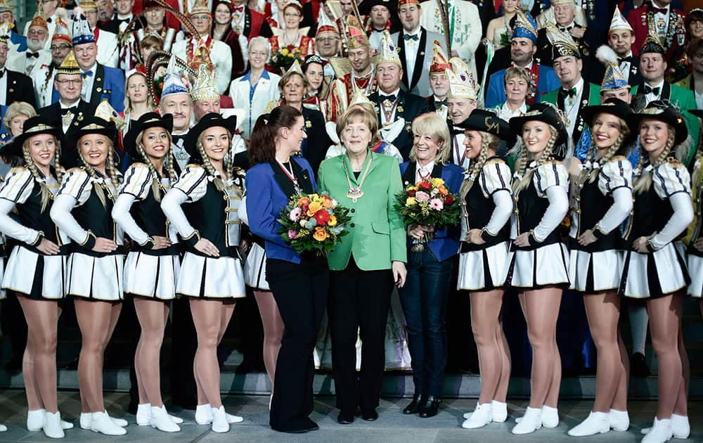 German Chancellor Angela Merkel poses with carnival dancers during a reception for carnival clubs from all over Germany at the chancellery in Berlin.