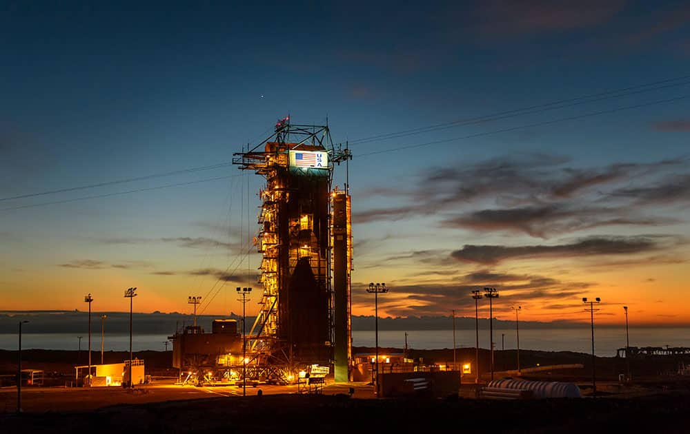 In this photo provided by NASA, the sun sets behind Space Launch Complex 2 with the Delta II rocket and the Soil Moisture Active Passive (SMAP) observatory protected by the service structure at Vandenberg Air Force Base, Calif. 