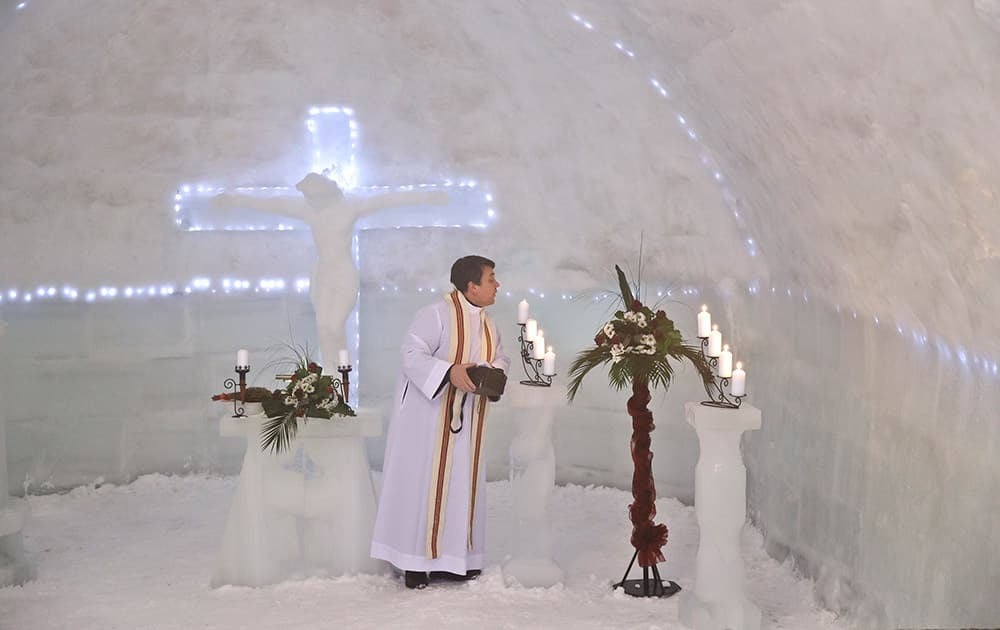 A Romanian priest puts out candles inside a church built entirely from ice blocks cut from a frozen lake after a blessing religious service at the Balea Lac resort in the Fagaras mountains, Romania.