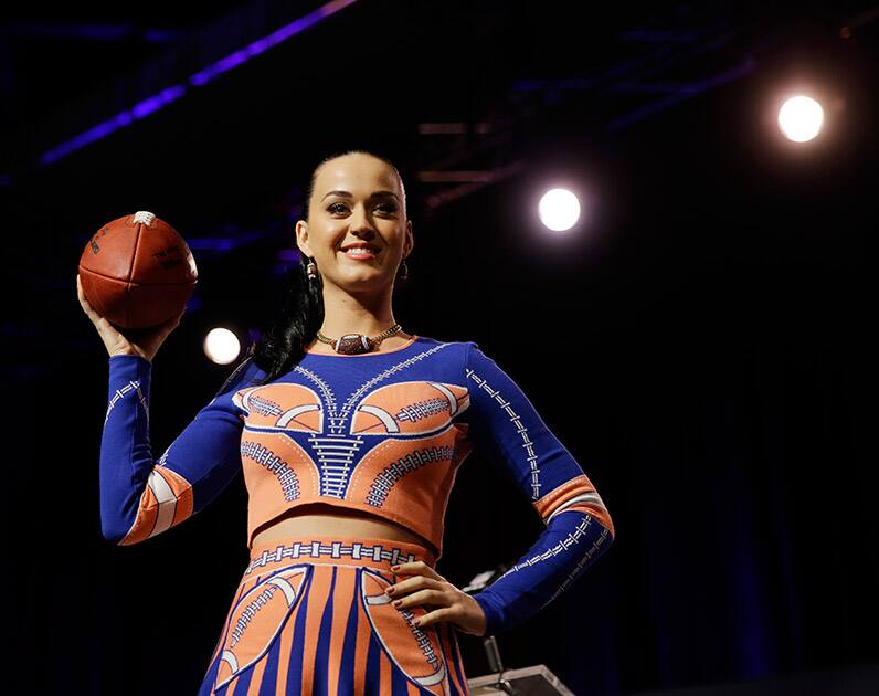 Katy Perry poses with a football at a news conference regarding the half time show for NFL Super Bowl XLIX football game, in Phoenix. 