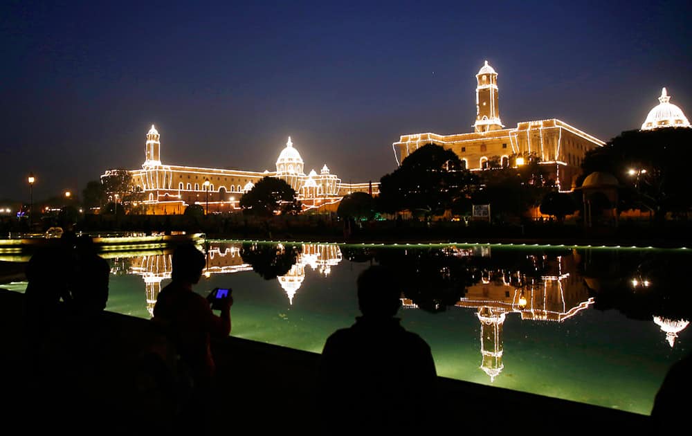 People take photographs and selfies against the illuminated Raisina Hill, which houses India's most important ministries and the presidential palace after Beating Retreat ceremony, in New Delhi.