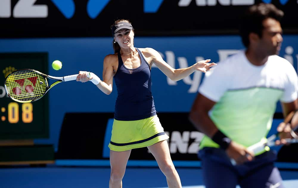 Martina Hingis of Switzerland, left, along with Leander Paes of India, makes a forehand return to Hsieh Su-Wei of Taiwan and Pablo Cuevas of Uruguay during their mixed doubles semifinal match at the Australian Open tennis championship in Melbourne.