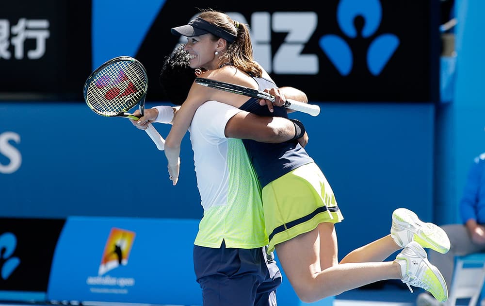 Martina Hingis of Switzerland celebrates with her partner Leander Paes of India after defeating Hsieh Su-Wei of Taiwan and Pablo Cuevas of Uruguay in their mixed doubles semifinal match at the Australian Open tennis championship in Melbourne.