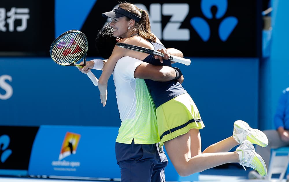 Martina Hingis of Switzerland celebrates with her partner Leander Paes of India after defeating Hsieh Su-Wei of Taiwan and Pablo Cuevas of Uruguay in their mixed doubles semifinal match at the Australian Open tennis championship in Melbourne.