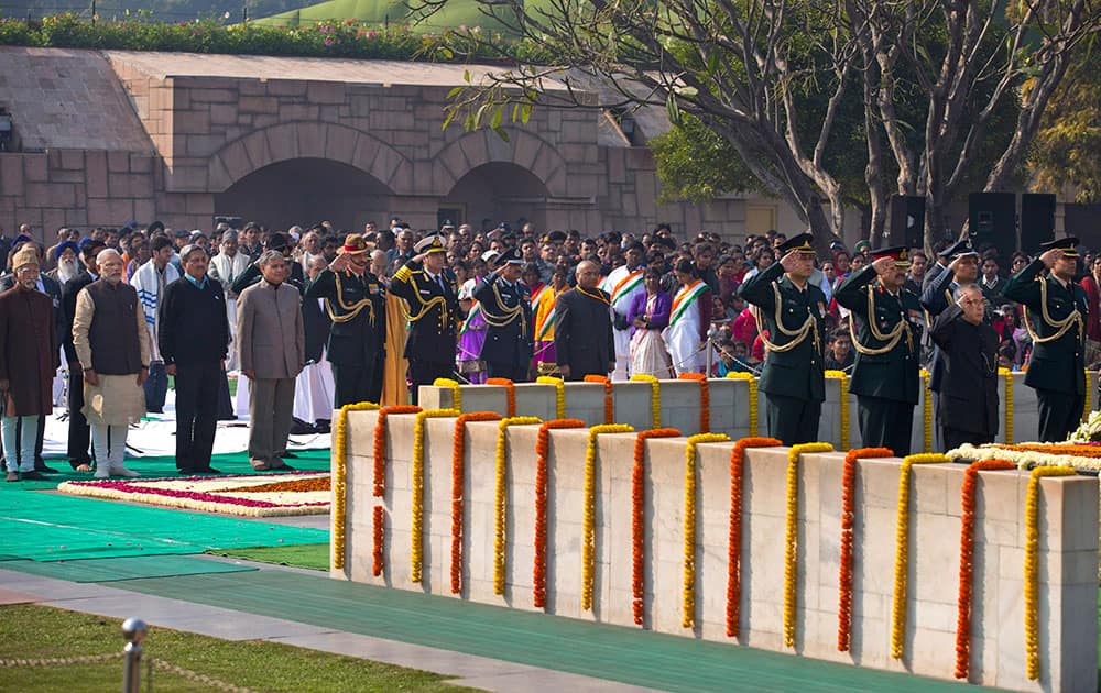 Prime Minister Narendra Modi, stands with other dignitaries as President Pranab Mukherjee, pays his respect at Rajghat, a memorial to Mahatma Gandhi, on his death anniversary in New Delhi.