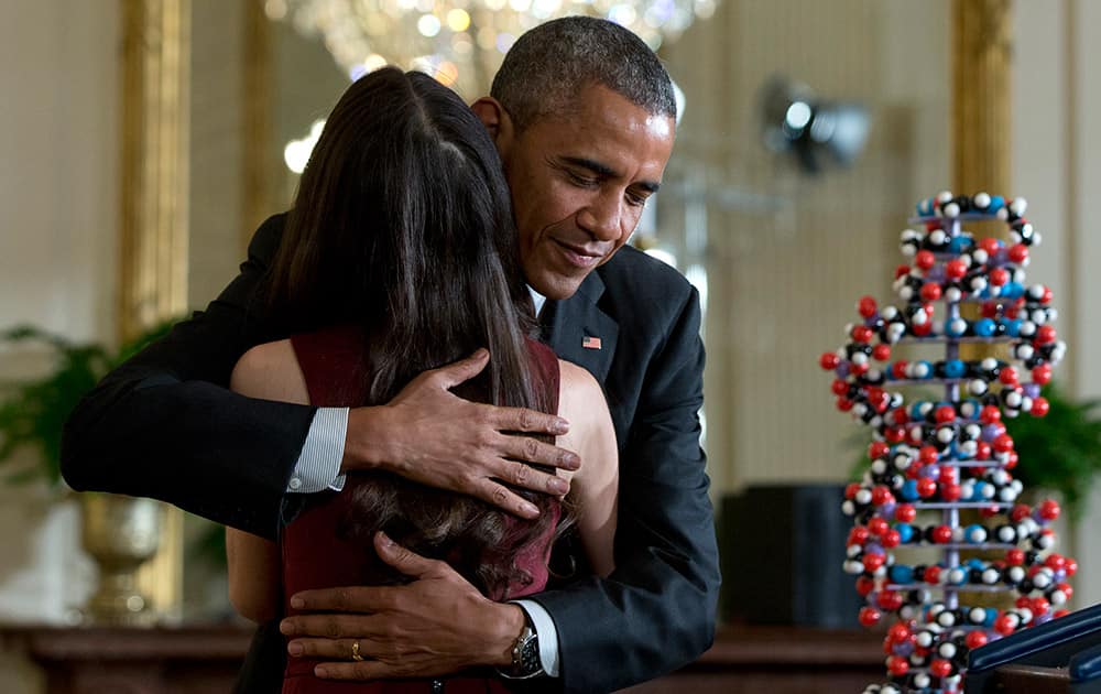 President Barack Obama embraces Elana Simon, 19, a student at Harvard University who met with the president at last year’s White House Science Fair, after she introduced him to speak in the East Room of the White House in Washington.