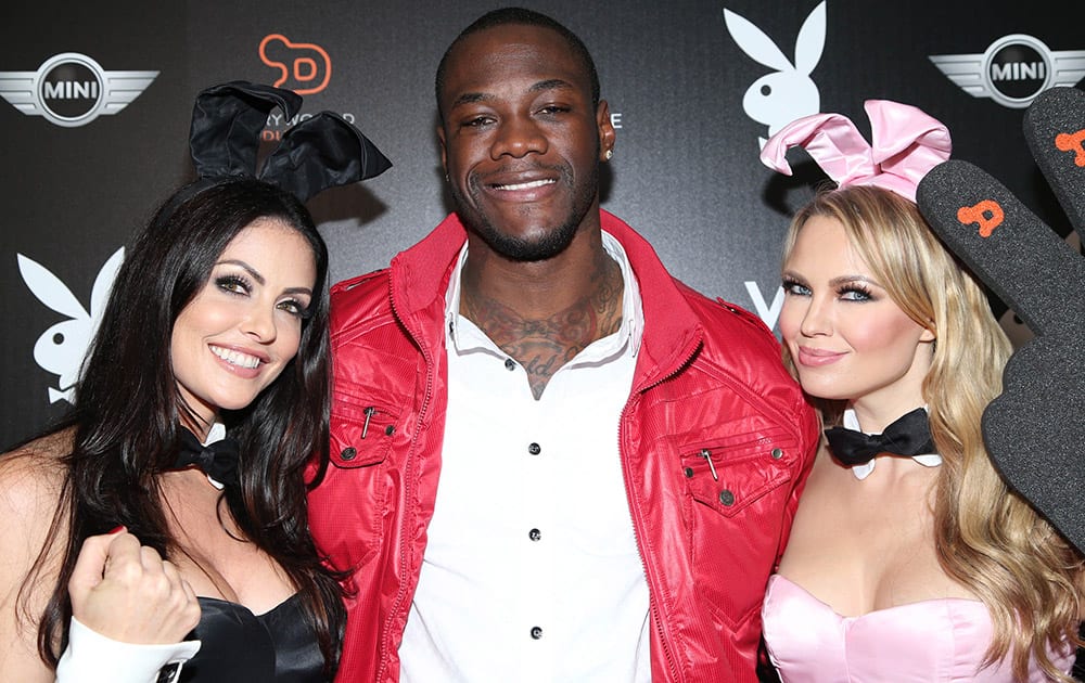 Deontay Wilder poses with Playboy Playmates on arrival at the Playboy Super Bowl XLIX Party in Scottsdale, Ariz.