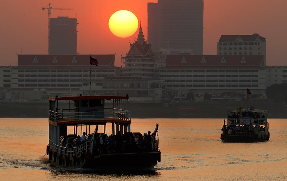 Ferries transport villagers, students and civil servants from Phnom Penh to Arey Ksat across the Mekong River as the sun sets in Phnom Penh, Cambodia.