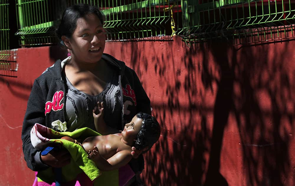 A woman walks to the market with her statue of baby Jesus, to have it fitted with a special gown for the upcoming Candlemas celebrations, in Cuajimalpa, on the western edge of Mexico City.