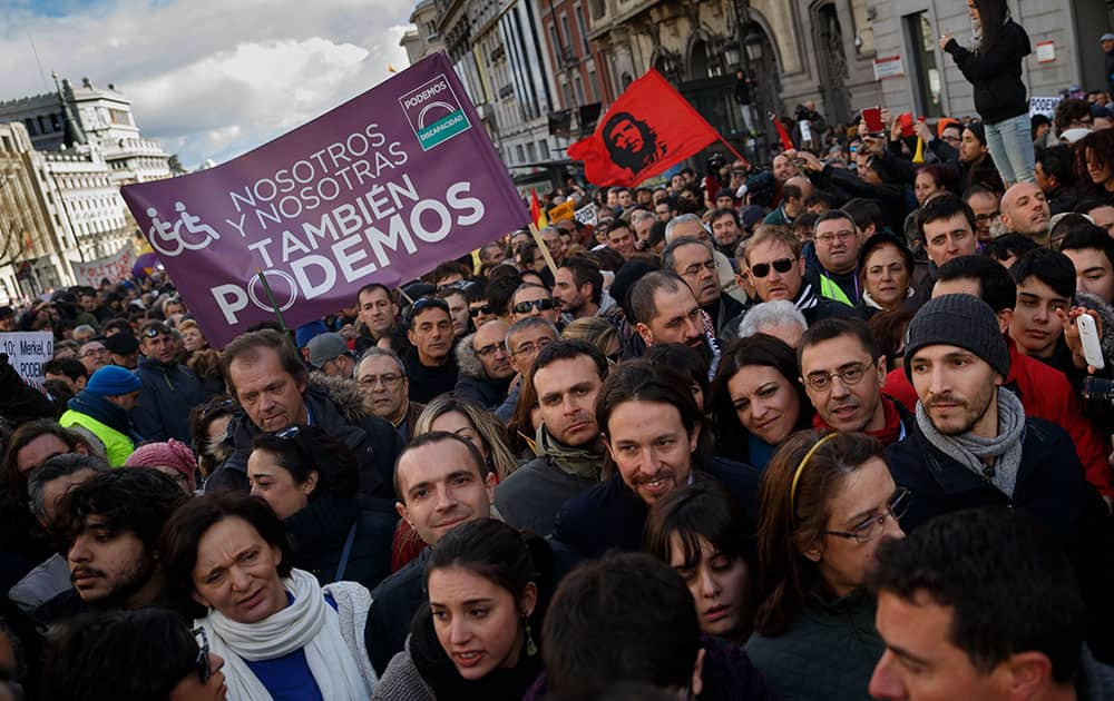 Pablo Iglesias, center right, leader of Spanish Podemos (We Can) left-wing party, smiles as he marches to give a speech at the main square of Madrid during a Podemos (We Can) party march in Madrid, Spain.