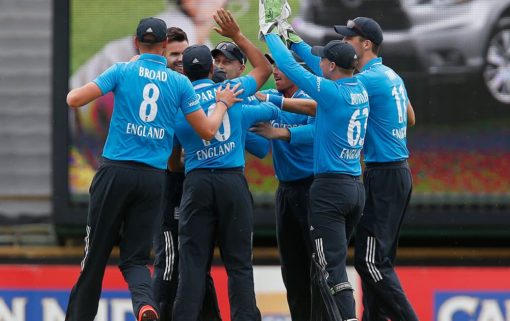 England's James Anderson, left rear, is congratulate by teammates after taking the wicket of Australia's Aaron Finch during their one day international cricket match in Perth, Australia.