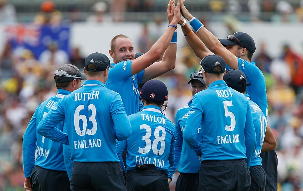 England's Stuart Broad, center, is congratulated by team mates after taking the wicket of Australia's George Bailey during their one-day international cricket match in Perth, Australia.