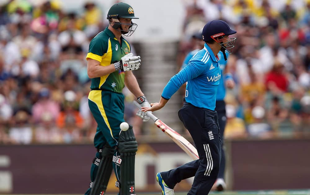 England's James Taylor, right, throws the ball behind after taking the catch to dismiss Australia's George Bailey, left, during their one-day international cricket match in Perth, Australia, Sunday.