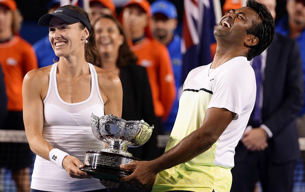 Martina Hingis of Switzerland, and Leander Paes of India hold trophy after defeating Kristina Mladenovic of France and Daniel Nestor of Canada in the mixed doubles final at the Australian Open tennis championship in Melbourne.