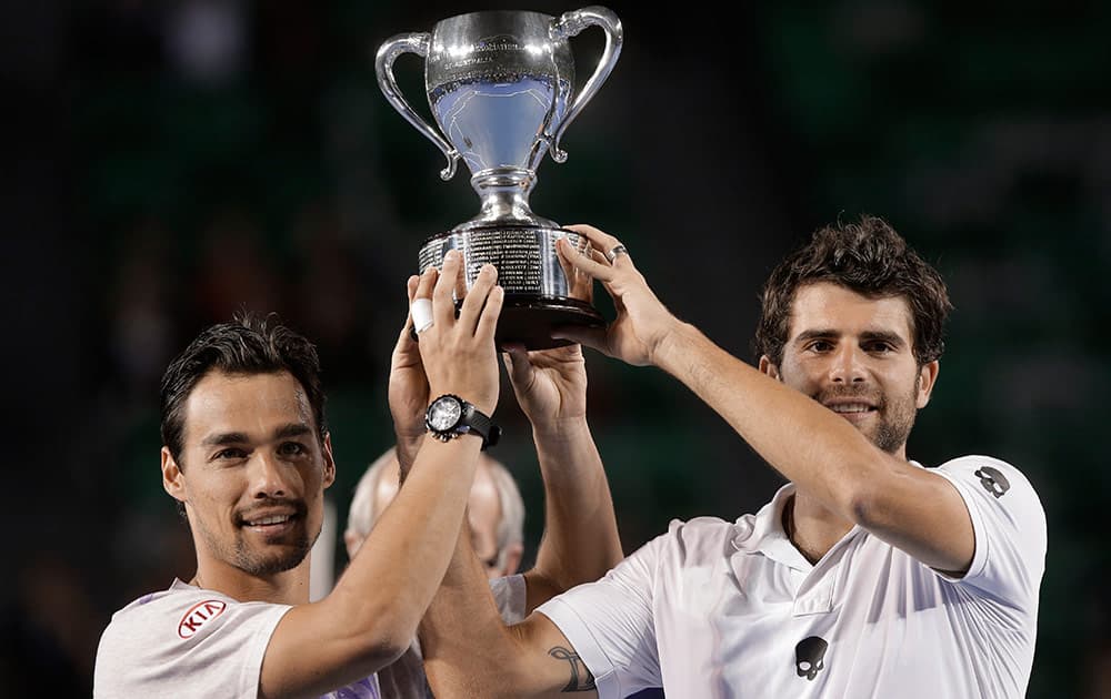 Italy’s Simone Bolelli, right, and Fabio Fognini lift the trophy after defeating France’s Pierre-Hugues Herbert Nicolas Mahut in the men's doubles final at the Australian Open tennis championship in Melbourne, Australia.