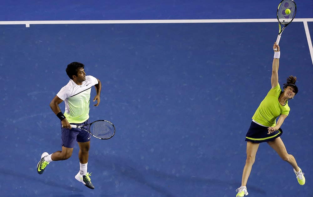 Martina Hingis of Switzerland, right, along with playing partner Leander Paes of India makes a return to Kristina Mladenovic of France and Daniel Nestor of Canada in the mixed doubles final at the Australian Open tennis championship in Melbourne, Australia, Sunday.