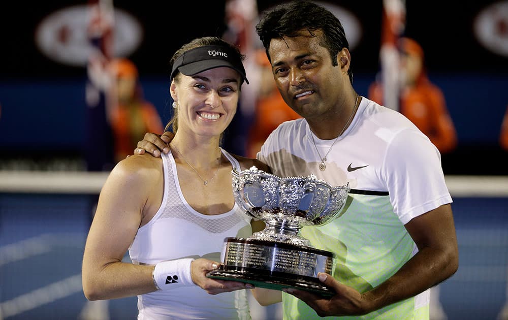 Martina Hingis of Switzerland, left, and Leander Paes of India hold trophy after defeating Kristina Mladenovic of France and Daniel Nestor of Canada in the mixed doubles final at the Australian Open tennis championship in Melbourne, Australia, Sunday.