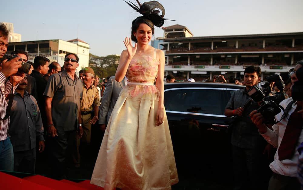 Bollywood actress Kangana Ranaut waves to media as she arrives for the Indian Derby 2015 at the Mahalaxmi race course in Mumbai, India. The derby is one of India's prestigious racing events.