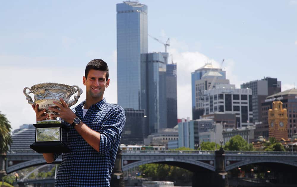 Novak Djokovic of Serbia poses with his Australian Open trophy, the day after defeating Andy Murray of Britain in the men's singles final at the Australian Open tennis championship.