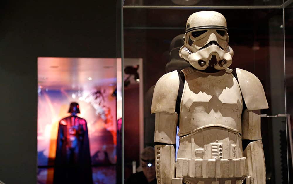 A stormtrooper costume is displayed with Darth Vader behind as part of an exhibit on the costumes of Star Wars at Seattle’s EMP Museum.