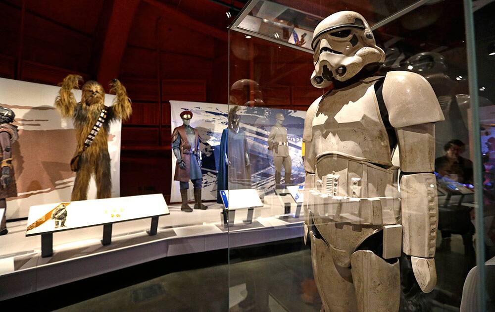 A stormtrooper costume is displayed in view of Chewbacca and military uniforms as part of an exhibit on the costumes of Star Wars at Seattle’s EMP Museum.