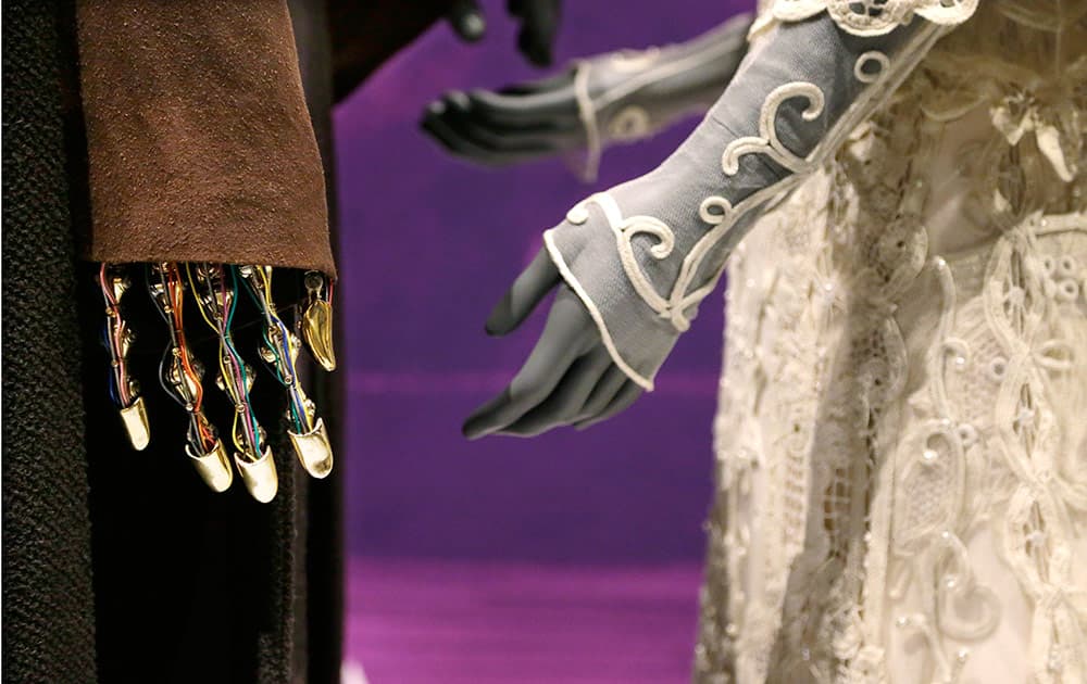 The robotic hand of Anakin Skywalker is seen with his Jedi robe and the wedding gown of his bride, Padme Amidala, while displayed as part of an exhibit on the costumes of Star Wars at Seattle’s EMP Museum.