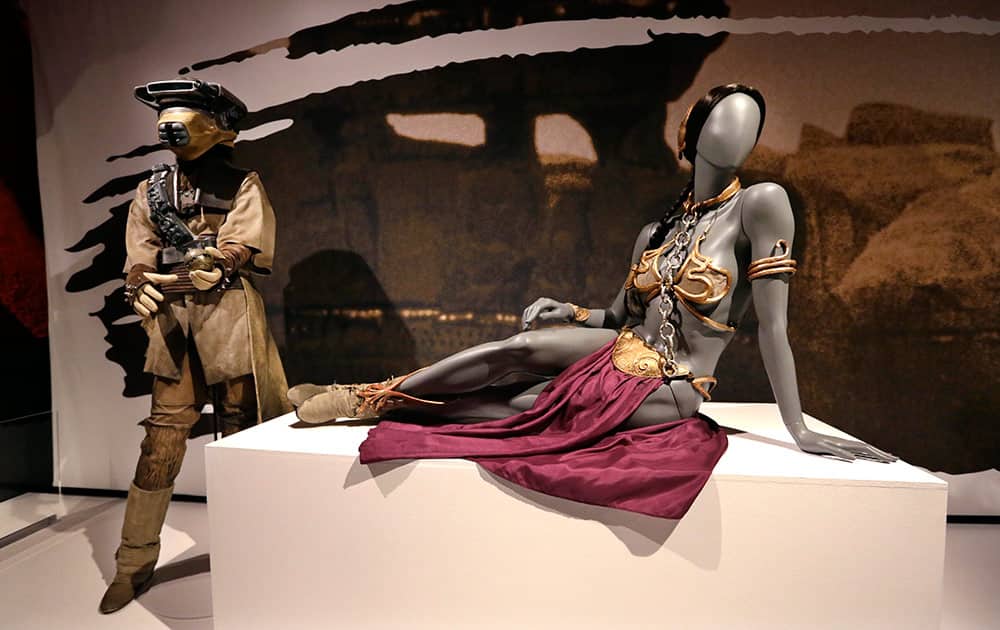 Princess Leia's slave bikini, right, and her Boushh disguise are displayed as part of an exhibit on the costumes of Star Wars at Seattle’s EMP Museum.