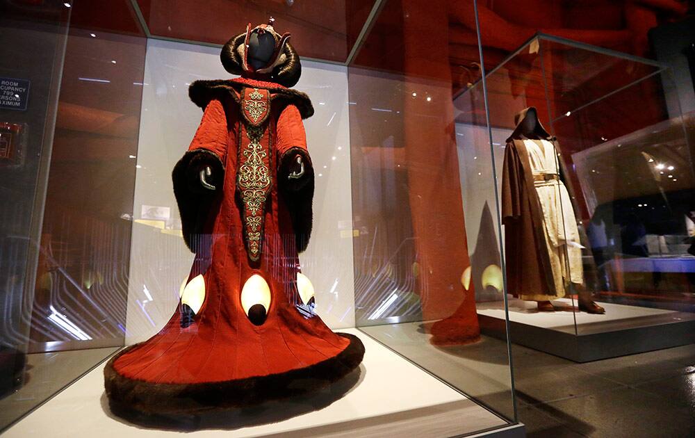 Queen Amidala's throne room gown, left, and Obi-Wan Kenobi's costume are displayed as part of an exhibit on the costumes of Star Wars at Seattle’s EMP Museum.
