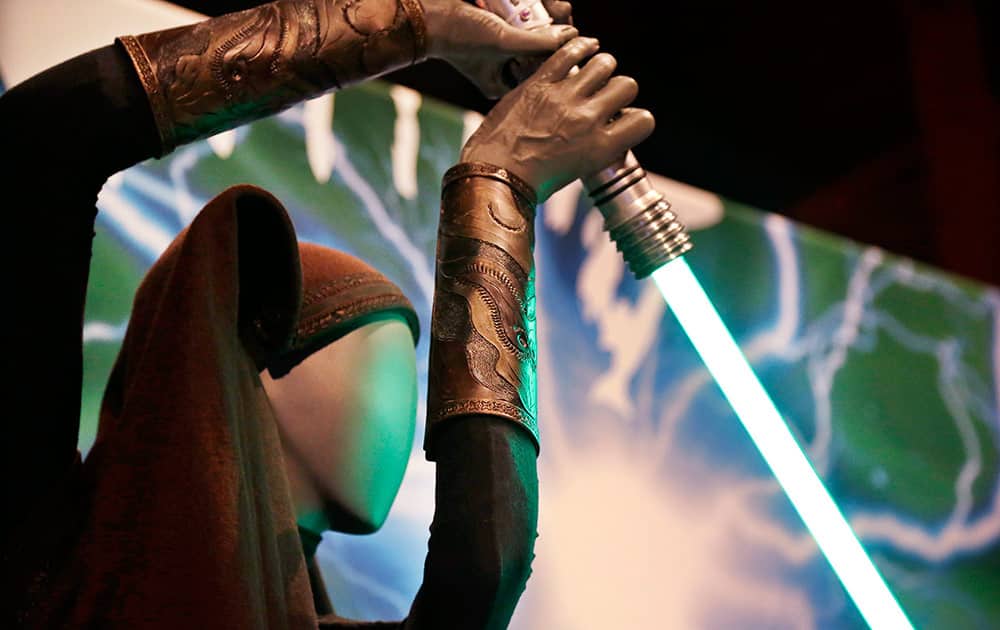 A Sith robe and lightsaber are displayed as part of an exhibit on the costumes of Star Wars at Seattle’s EMP Museum.