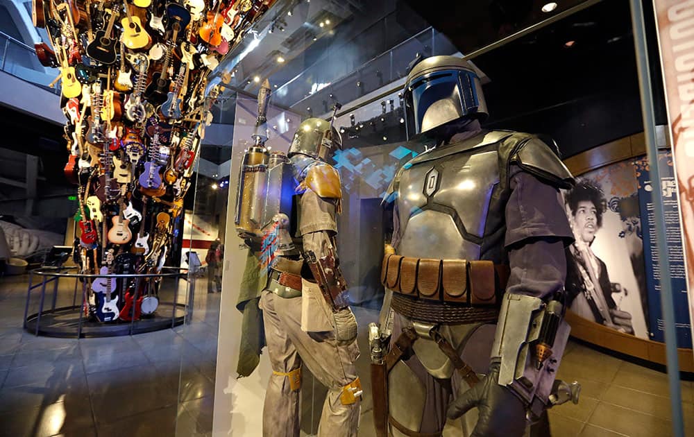 Boba Fett costumes are displayed as part of an exhibit on the costumes of Star Wars in view of an existing guitar sculpture at Seattle’s EMP Museum.