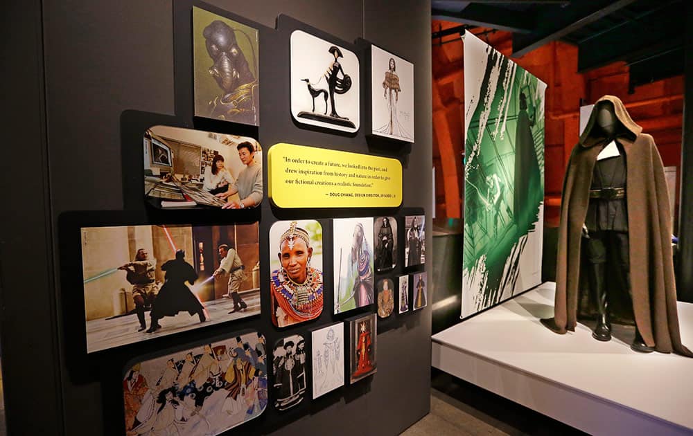 A photographic display near a Jedi robe gives information about cultural influences on Star Wars costumes as part of an exhibit on the costumes of Star Wars at Seattle’s EMP Museum.