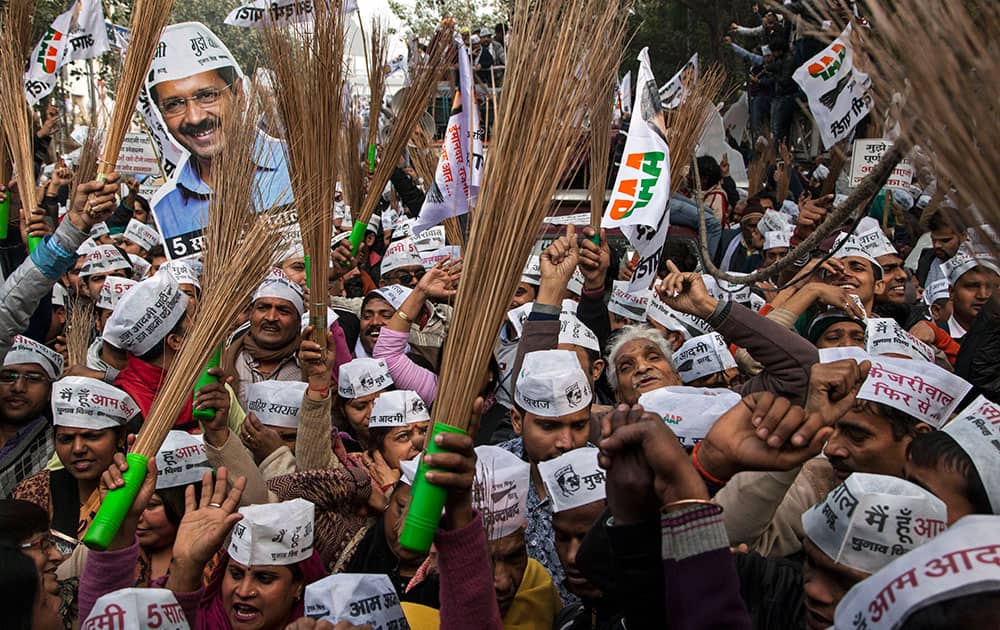 Aam Aadmi Party (AAP), or Common Man's Party supporters hold brooms, their party symbol, as they cheer for AAP chief Arvind Kerjiwal during a rally ahead of filing his nomination papers for the Delhi state elections in New Delhi, India, Tuesday, Jan. 20, 2015. 