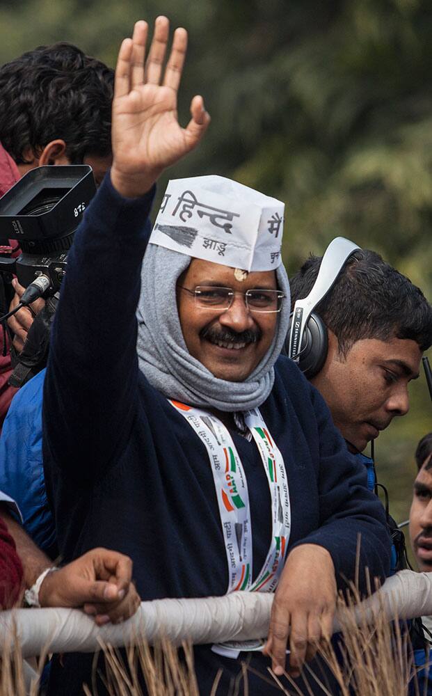 Aam Aadmi Party (AAP) or Common Man's Party chief Arvind Kerjiwal waves to his supporters as he arrives for his road show ahead of filing his nomination papers for the Delhi state elections in New Delhi, India.