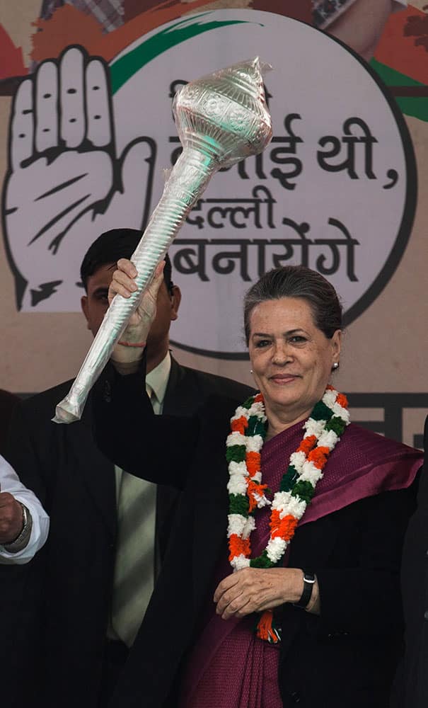 Congress party president Sonia Gandhi displays a ceremonial mace that was presented to her during a campaign rally ahead of Delhi state elections in New Delhi.
