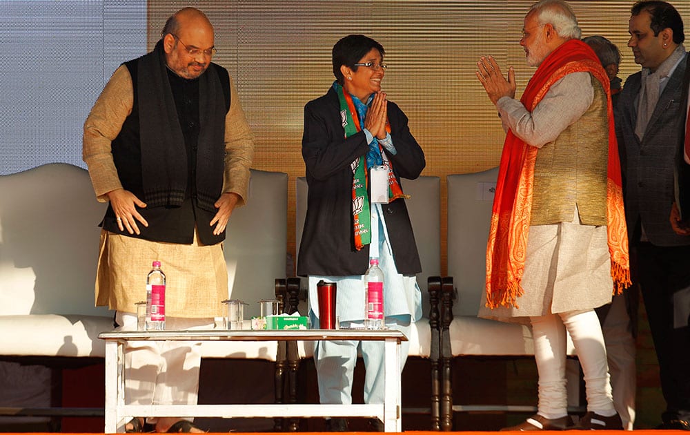 Indian Prime Minister Narendra Modi, right, greets Bharatiya Janata Party's chief ministerial candidate Kiran Bedi, second left, as party President Amit Shah stands by during an election campaign rally in New Delhi.