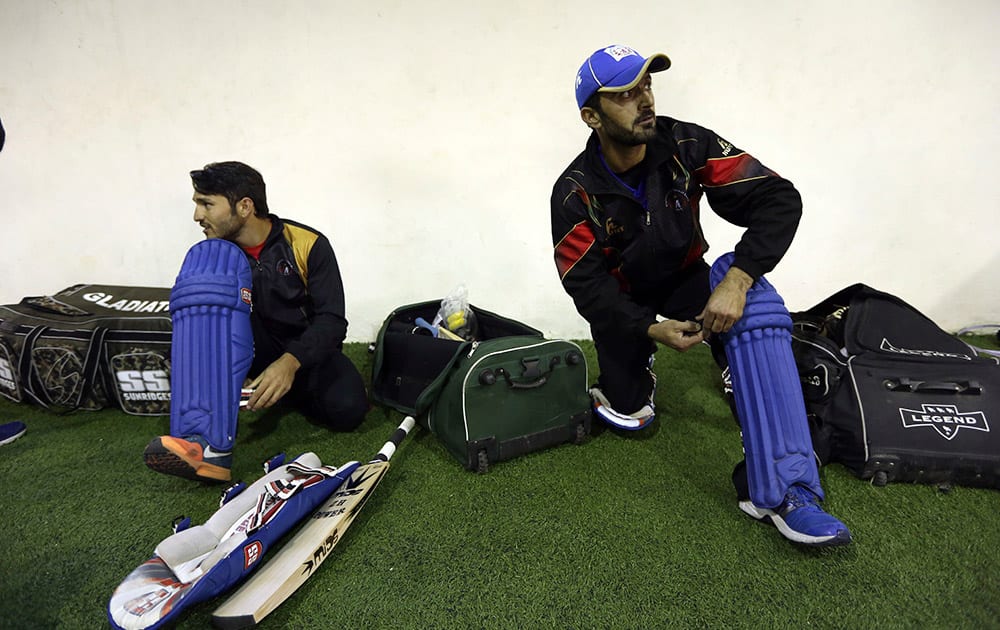 Afghan cricket player Nawroz Mangal, puts on his pad during a practice session at Kabul cricket academy training center, in Kabul, Afghanistan.