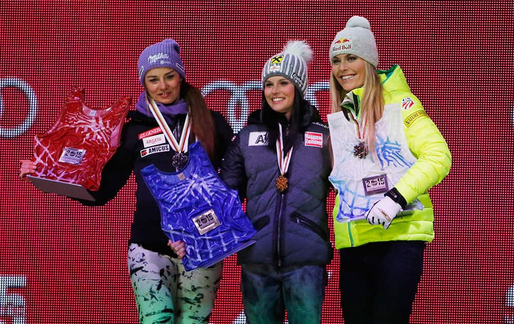 From left, Slovenia's Tina Maze, second place, Austria's Anna Fenninger, first place, and United States' Lindsey Vonn, third place, celebrate on the podium during a medal ceremony for the women's super-G competition at the alpine skiing world championships in Vail, Colo. 