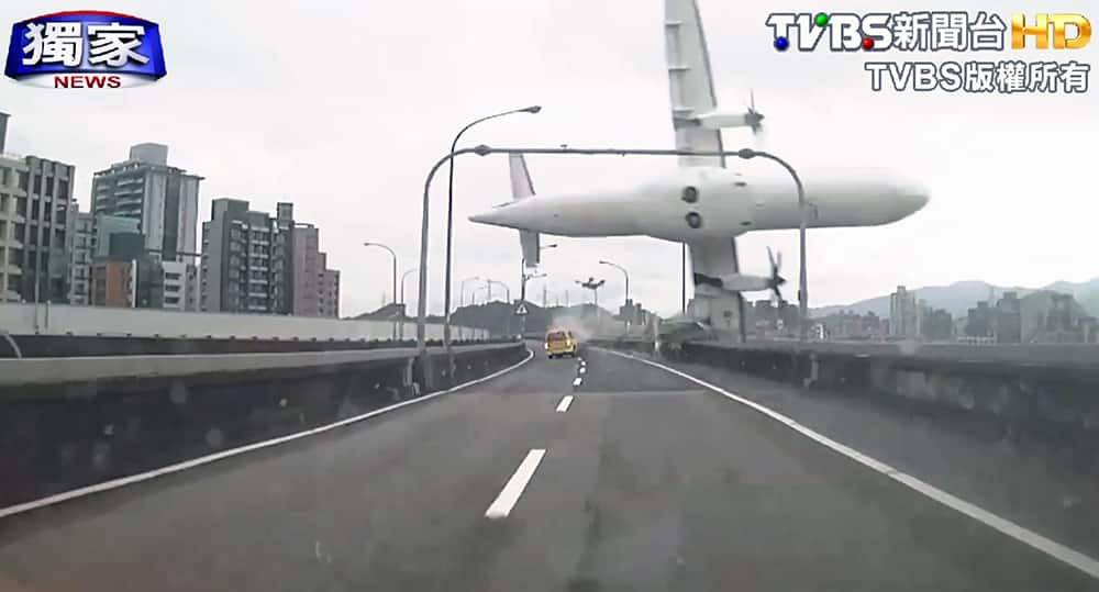 This image taken from video provided by TVBS shows a commercial airplane clipping an elevated roadway just before it careened into a river in Taipei, Taiwan. The ATR-72 prop-jet aircraft had 58 people aboard.