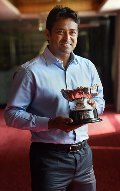 Tennis player Leander Paes poses with his Australian Open mixed doubles trophy in Mumbai.