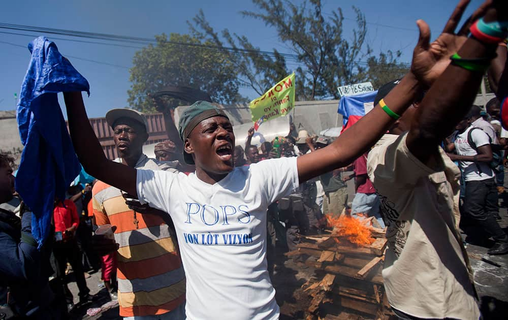 Demonstrators use wood, gas, fire and salt to call forth a spirit to ask for protection during a voodoo ceremony before the start of a protest demanding the resignation of President Michel Martelly in Port-au-Prince, Haiti.