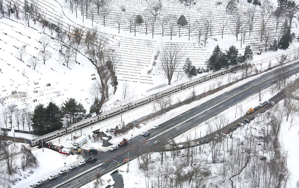 In this aerial photo, a Metro-North Railroad commuter train remains on the tracks in Valhalla, N.Y., after being involved in a deadly SUV and commuter train accident. 