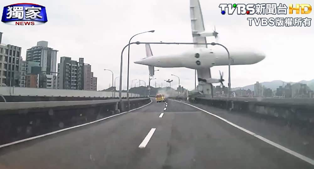 This image taken from video provided by TVBS shows a commercial airplane clipping an elevated roadway just before it careened into a river in Taipei, Taiwan.