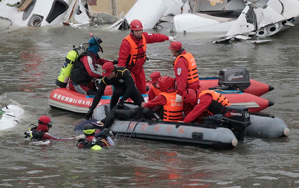 Emergency personnel retrieve the body of a passenger of a commercial plane after it crashed in the water in Taipei, Taiwan.